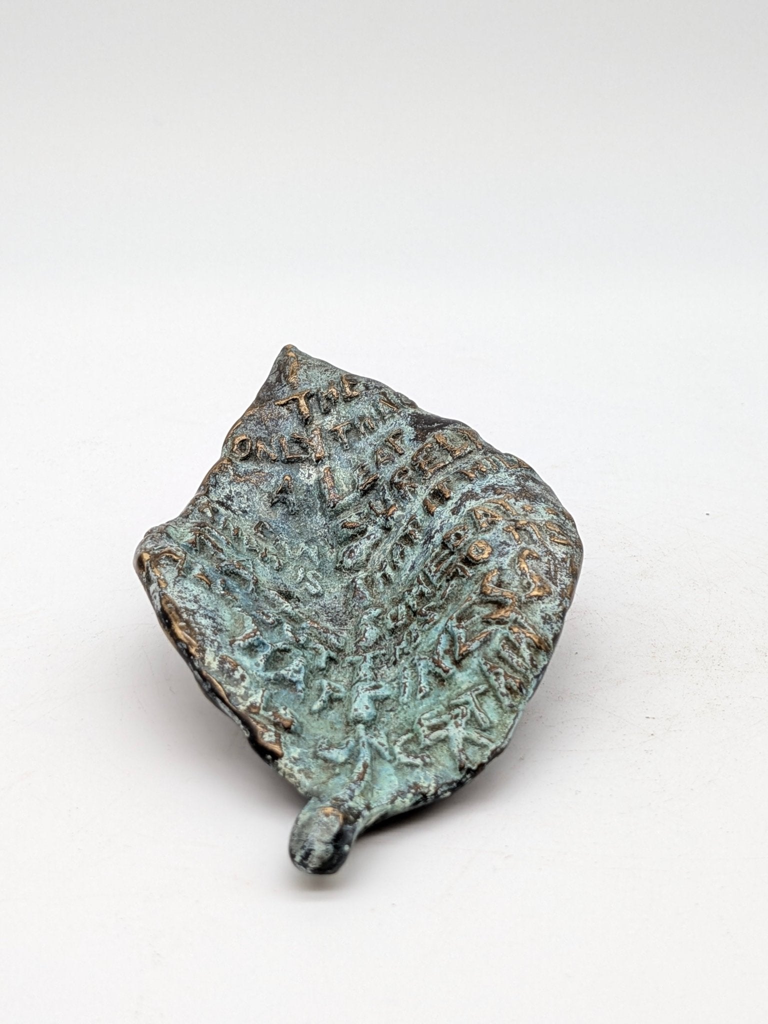 Kunstenaar onbekend - Bronzen blad met tekst en gezicht