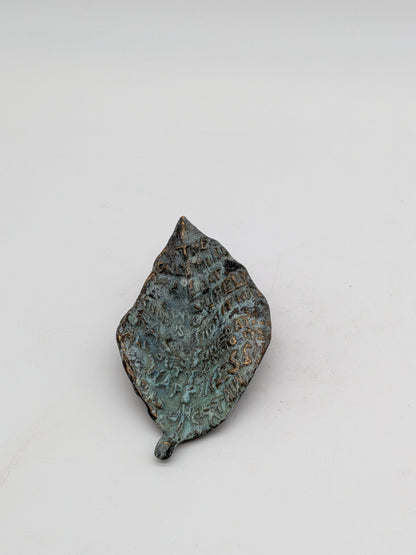 Kunstenaar onbekend - Bronzen blad met tekst en gezicht